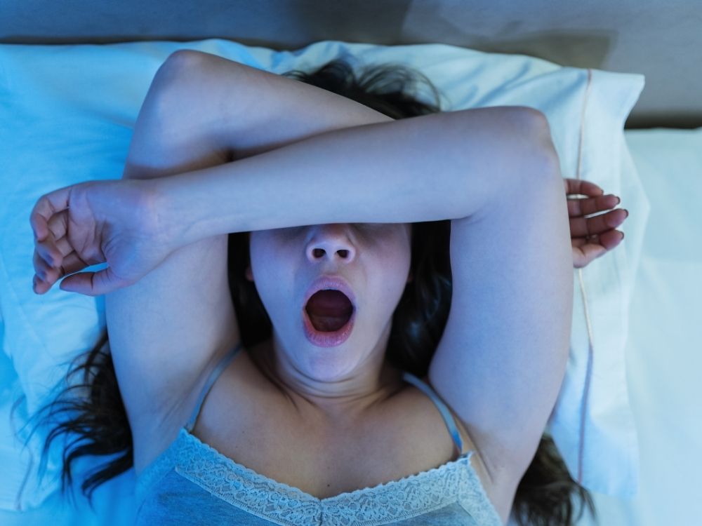 Chica en la cama intentando dormir