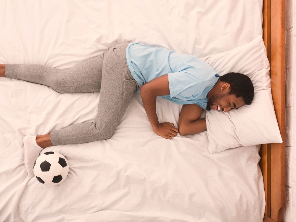 Persona en la cama con un balón de fútbol