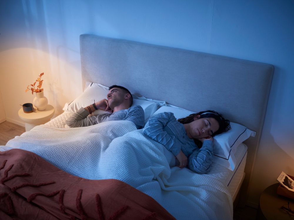 Pareja durmiendo en un colchón KHAMA con luz azul