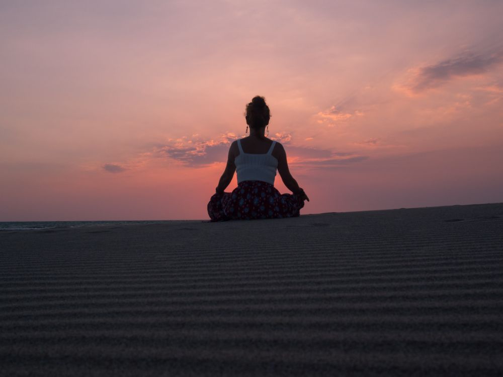 Chica meditando en un desierto