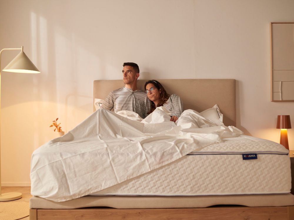 Pareja en un colchón KHAMA tapados mirando por la ventana