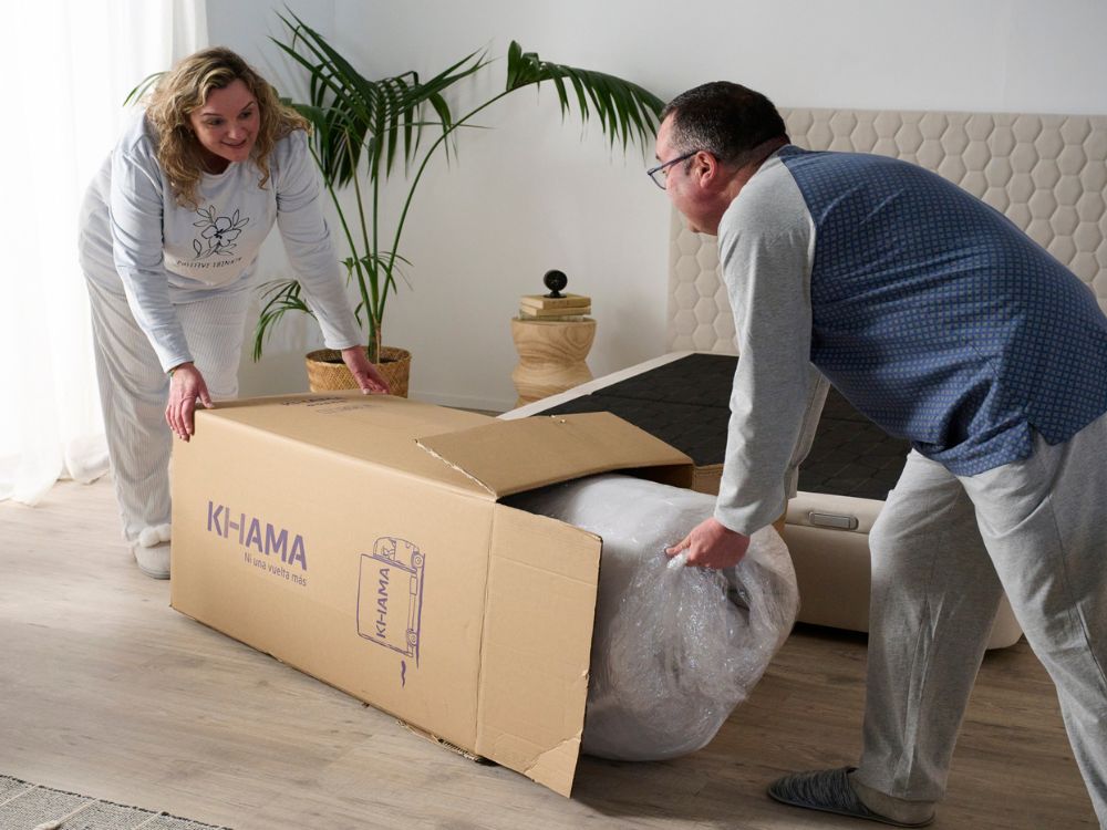 Pareja desembalando su colchón KHAMA tras una mudanza